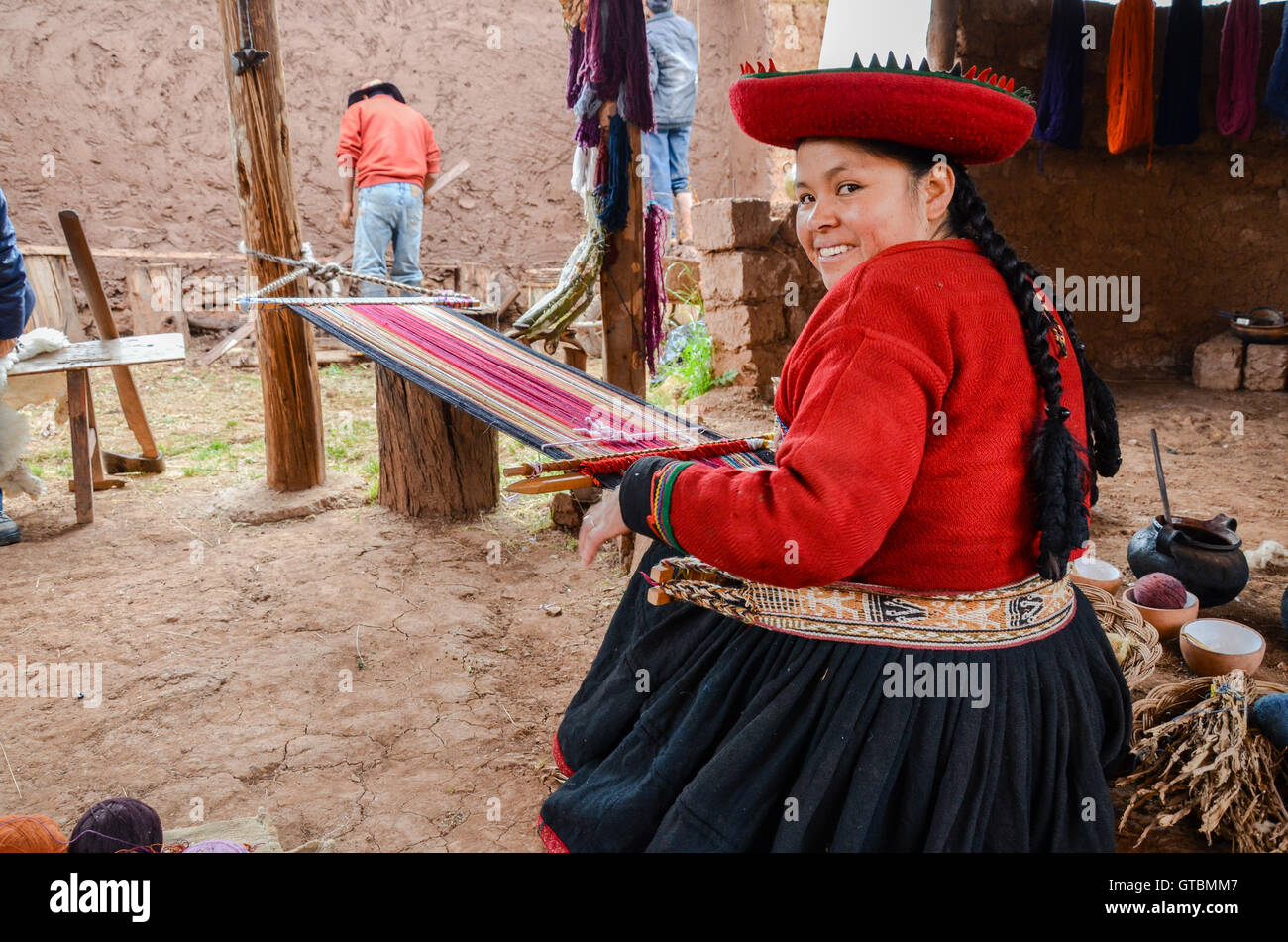 Einheimische Cusquena Frau in bunten Trachten gekleidet arbeitet auf einem Webstuhl vor ihrem Haus Stockfoto