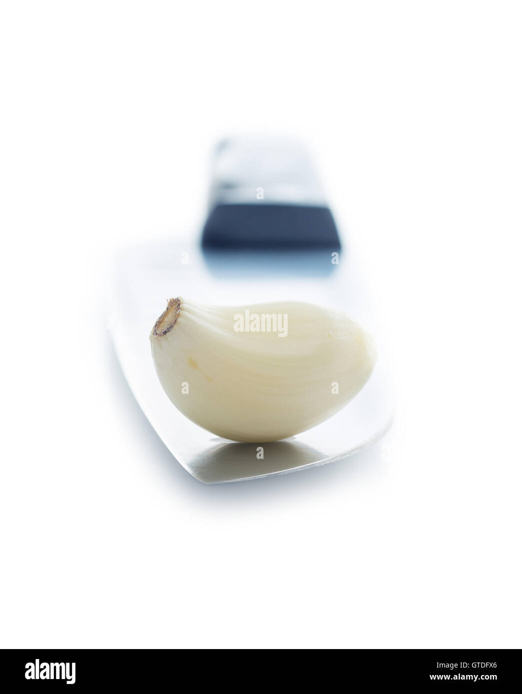 Geschälte Knoblauchzehe auf das Messer. Isoliert auf weißem Hintergrund. Stockfoto