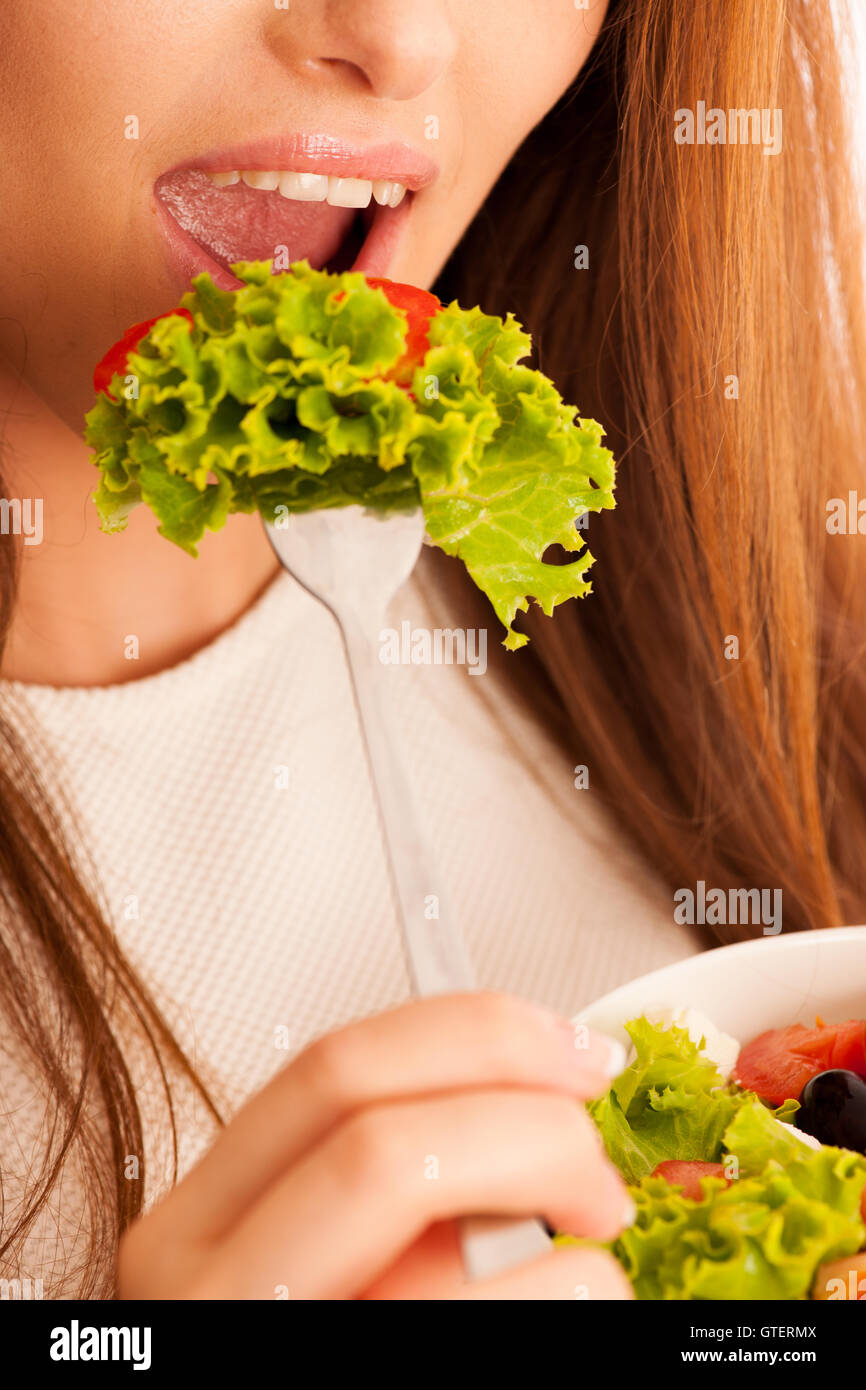 gesunde Ernährung - Frau isst eine Schüssel griechischen Salat isoliert auf weißem Hintergrund - vegetarische Mahlzeit Stockfoto