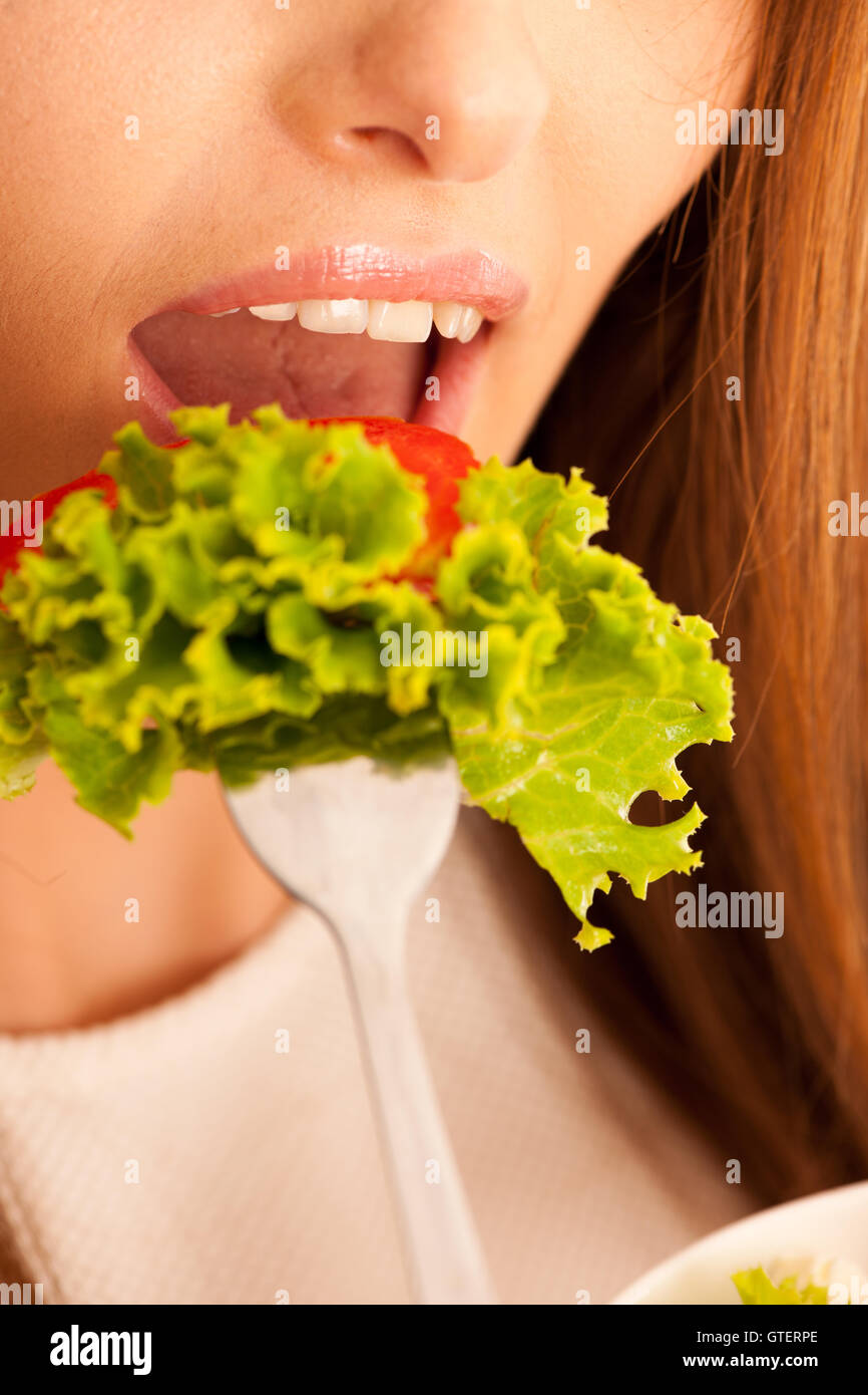 gesunde Ernährung - Frau isst eine Schüssel griechischen Salat isoliert auf weißem Hintergrund - vegetarische Mahlzeit Stockfoto
