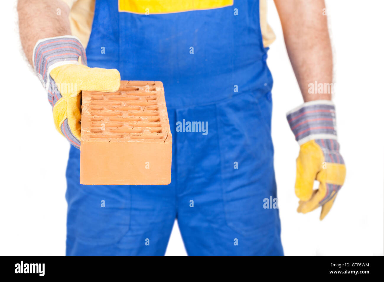 Arbeiter-Generator, ein Backstein in der Hand, isoliert auf weiss. Bild mit Beschneidungspfad. Stockfoto