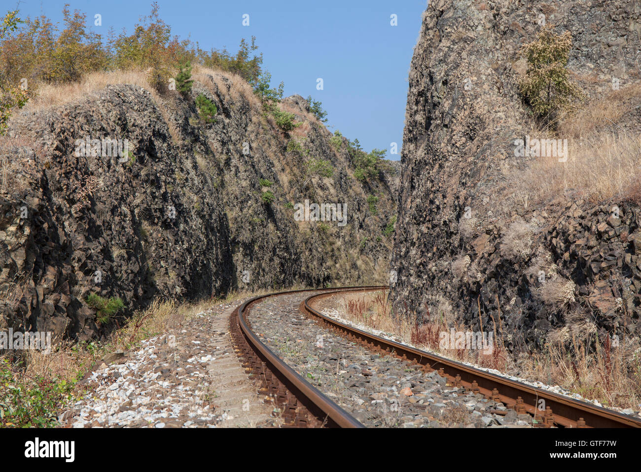 Kurve der Bahnlinie führt durch enge Felsenschlucht. Stockfoto