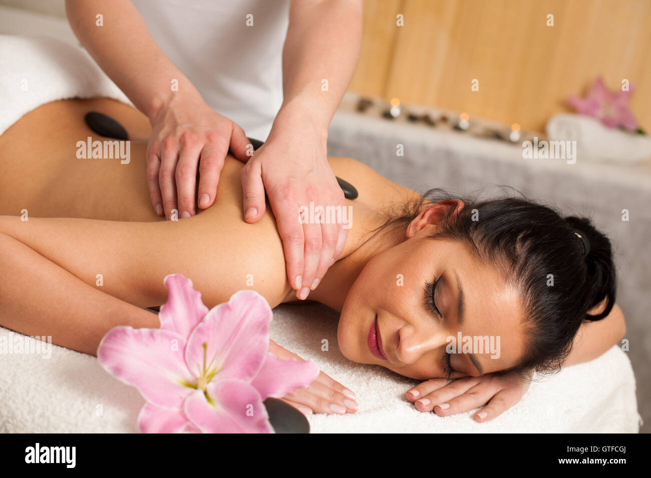 Schöne junge Frau mit einer erholsamen Massage im Wellness-Studio - Wellness Stockfoto