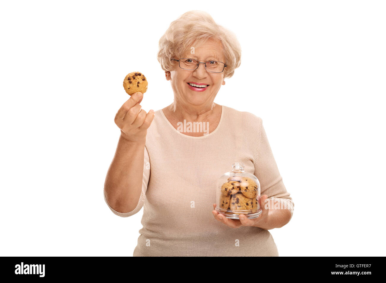 Glücklich Reife Frau hält ein Cookie und ein Glas voller Cookies isoliert auf weißem Hintergrund Stockfoto