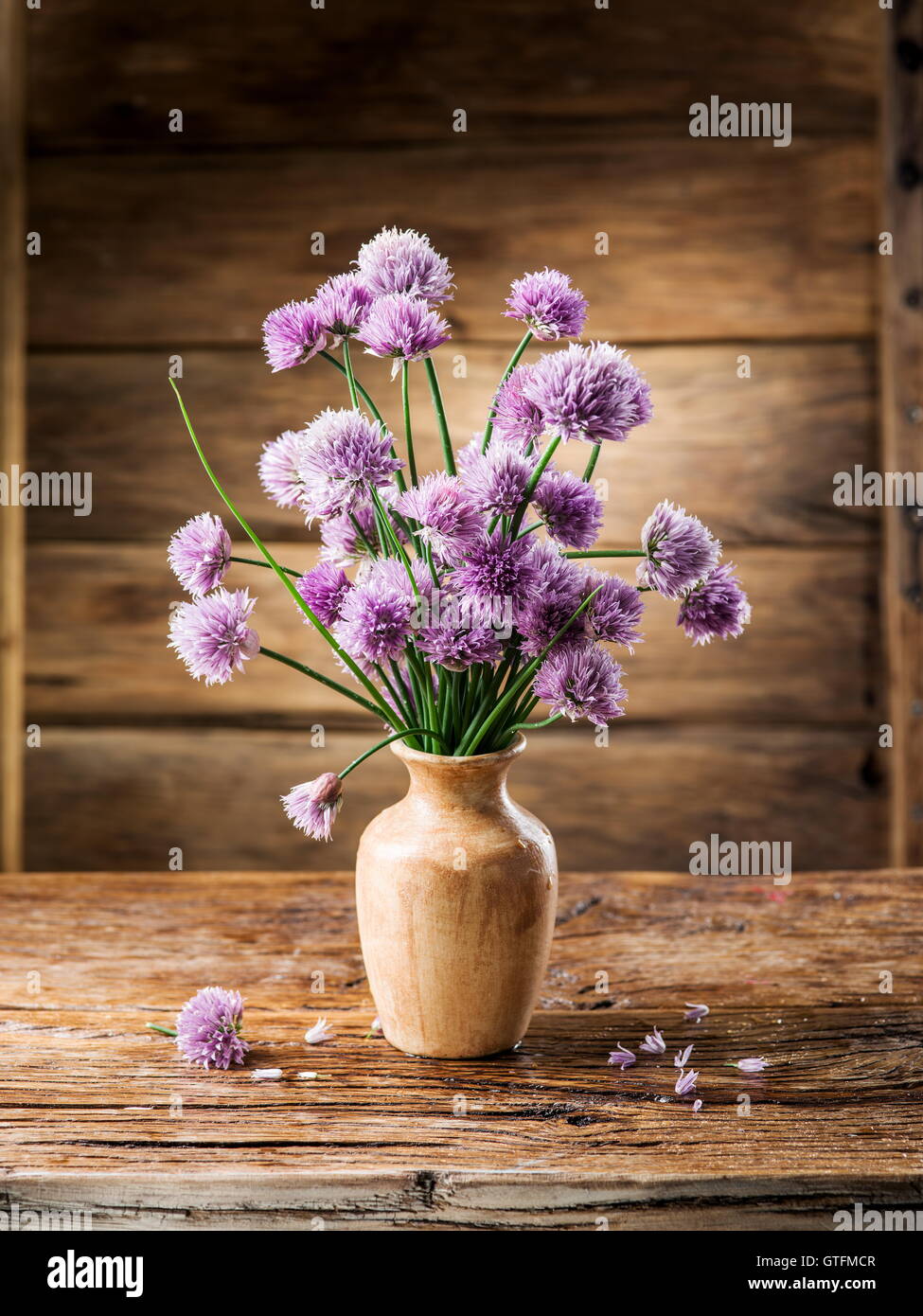 Blumenstrauß in der Vase auf dem Holztisch Zwiebel (Schnittlauch). Stockfoto