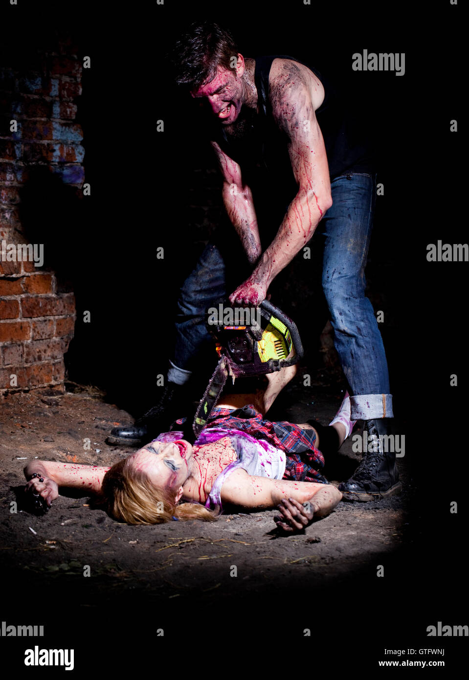 Schreckliche verrückter auf einem dunklen Hintergrund und chainesaw Stockfoto