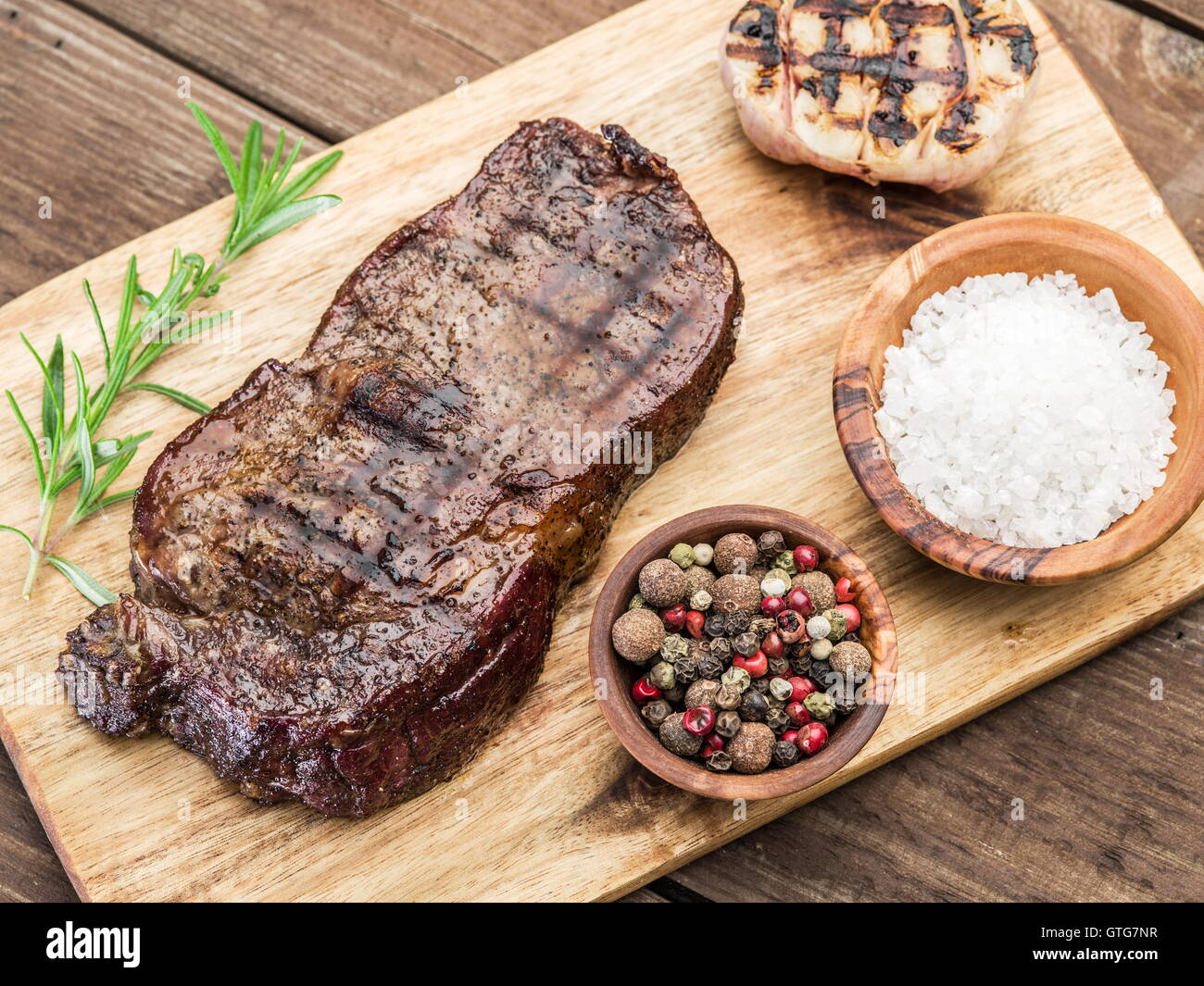 Ribeye Steak mit Gewürzen auf dem Tablett aus Holz. Stockfoto