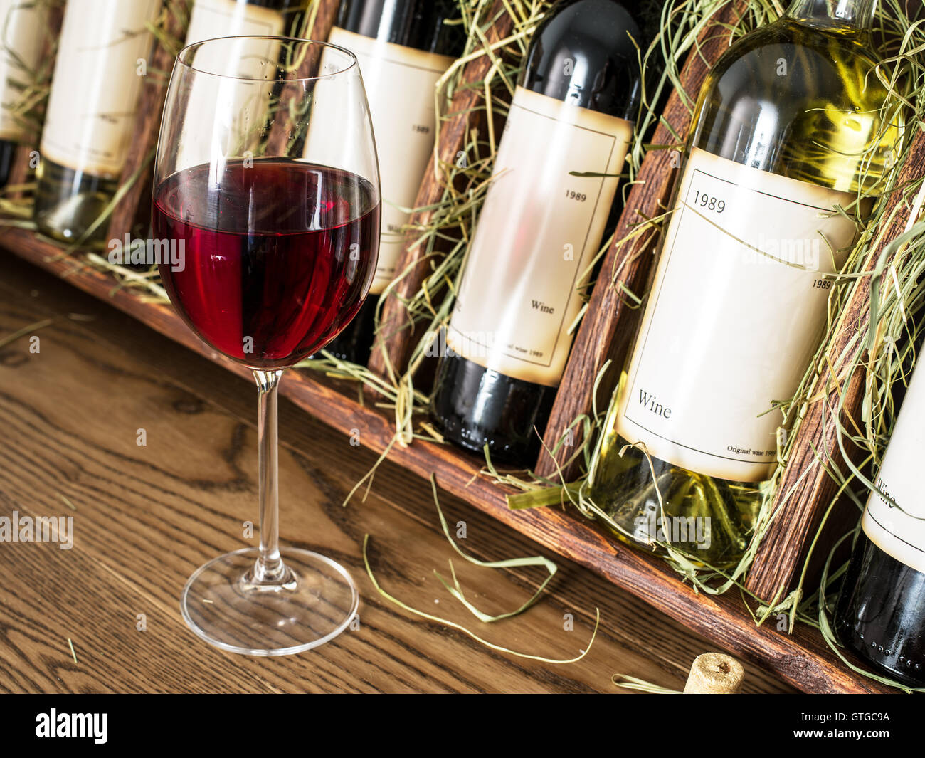 Glas Rot Wein und Flaschen auf dem Hintergrund. Stockfoto