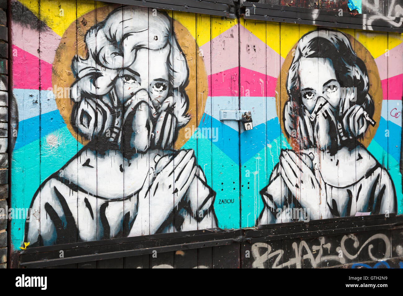 bunte Wandbild Graffiti von zwei Frauen mit Spraydosen und Gesichtsmasken von Zabou auf Brick Lane, Shoreditch, London im September Stockfoto