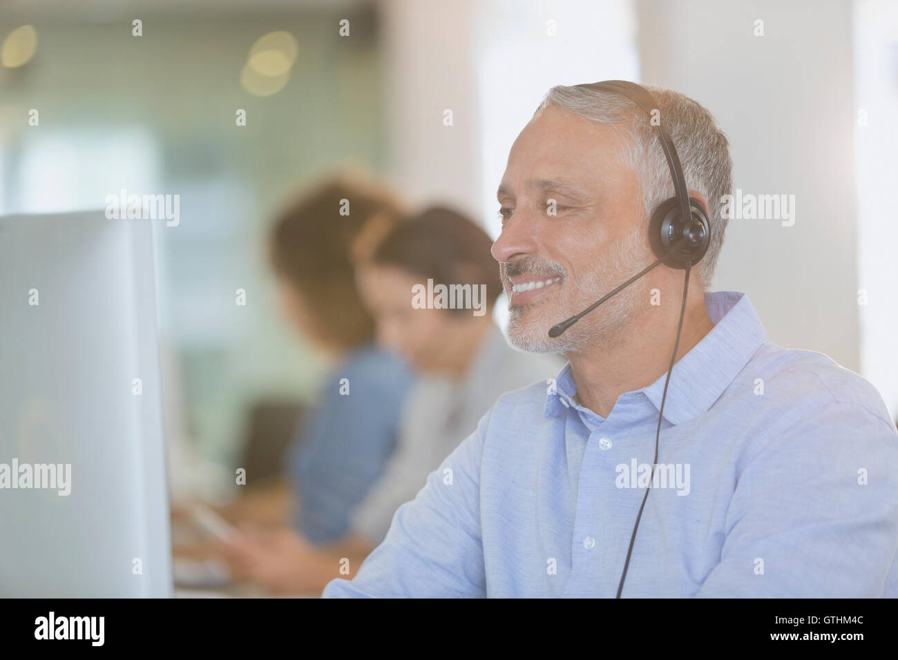 Geschäftsmann mit Kopfhörer arbeiten am Computer im Büro Stockfoto