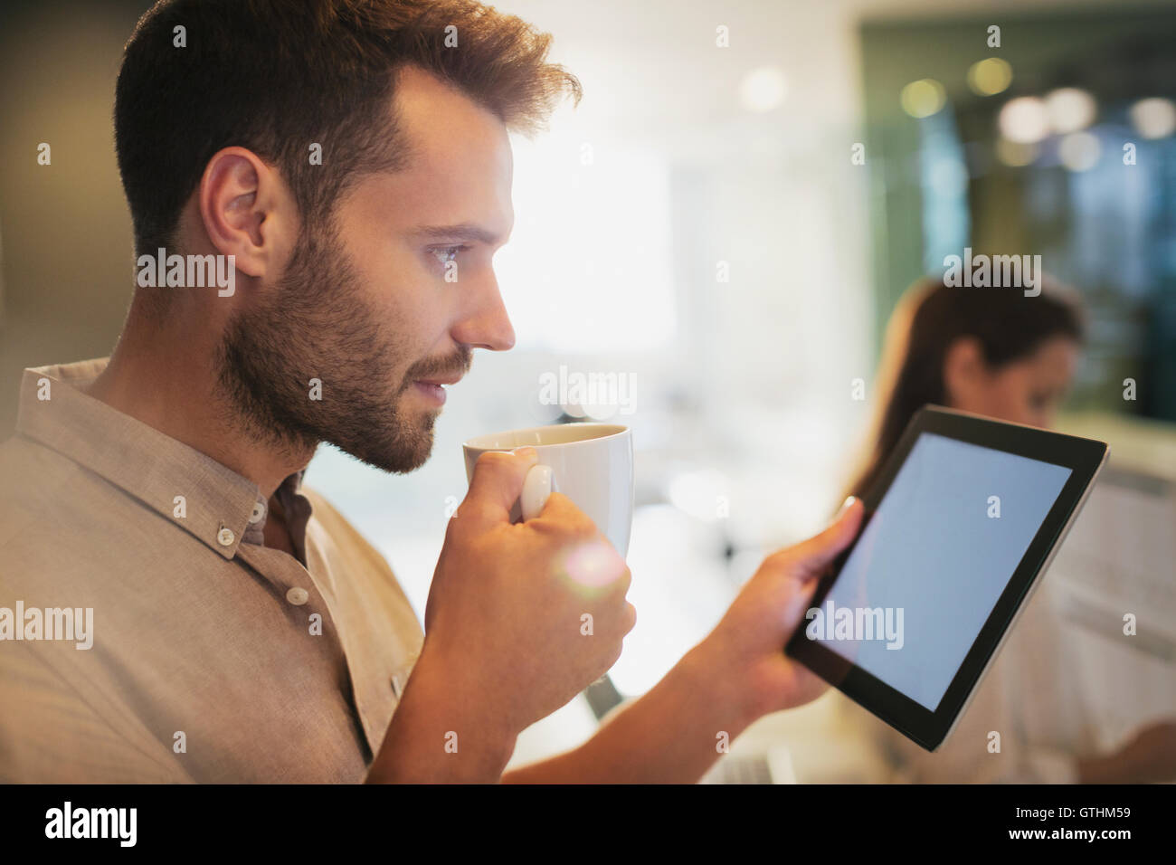Geschäftsmann Kaffeetrinken mit digital-Tablette in office Stockfoto