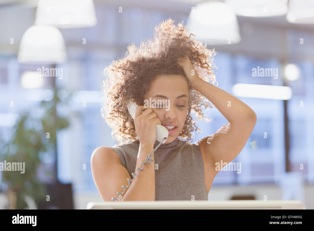 Geschäftsfrau Gespräch am Telefon mit der Hand im Haar Stockfoto