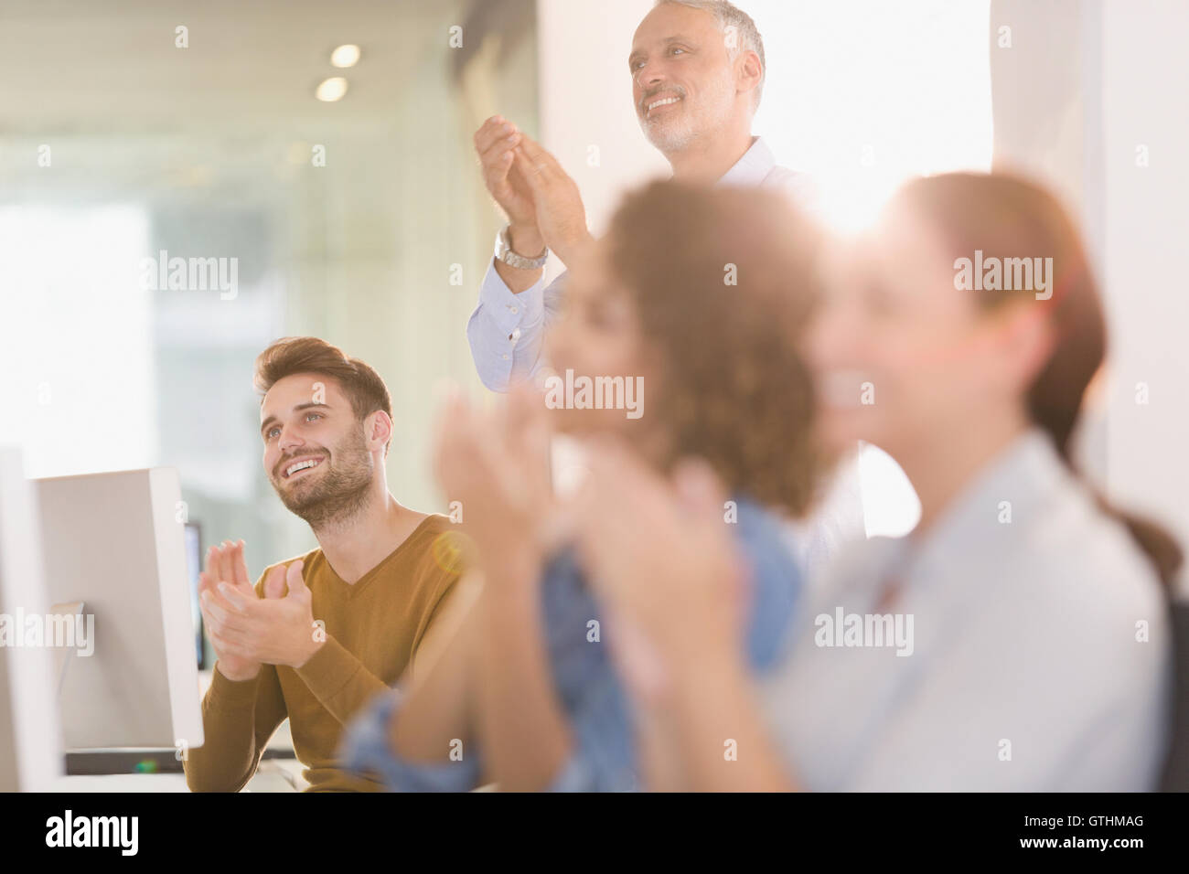 Business-Leute klatschten im Büro Stockfoto