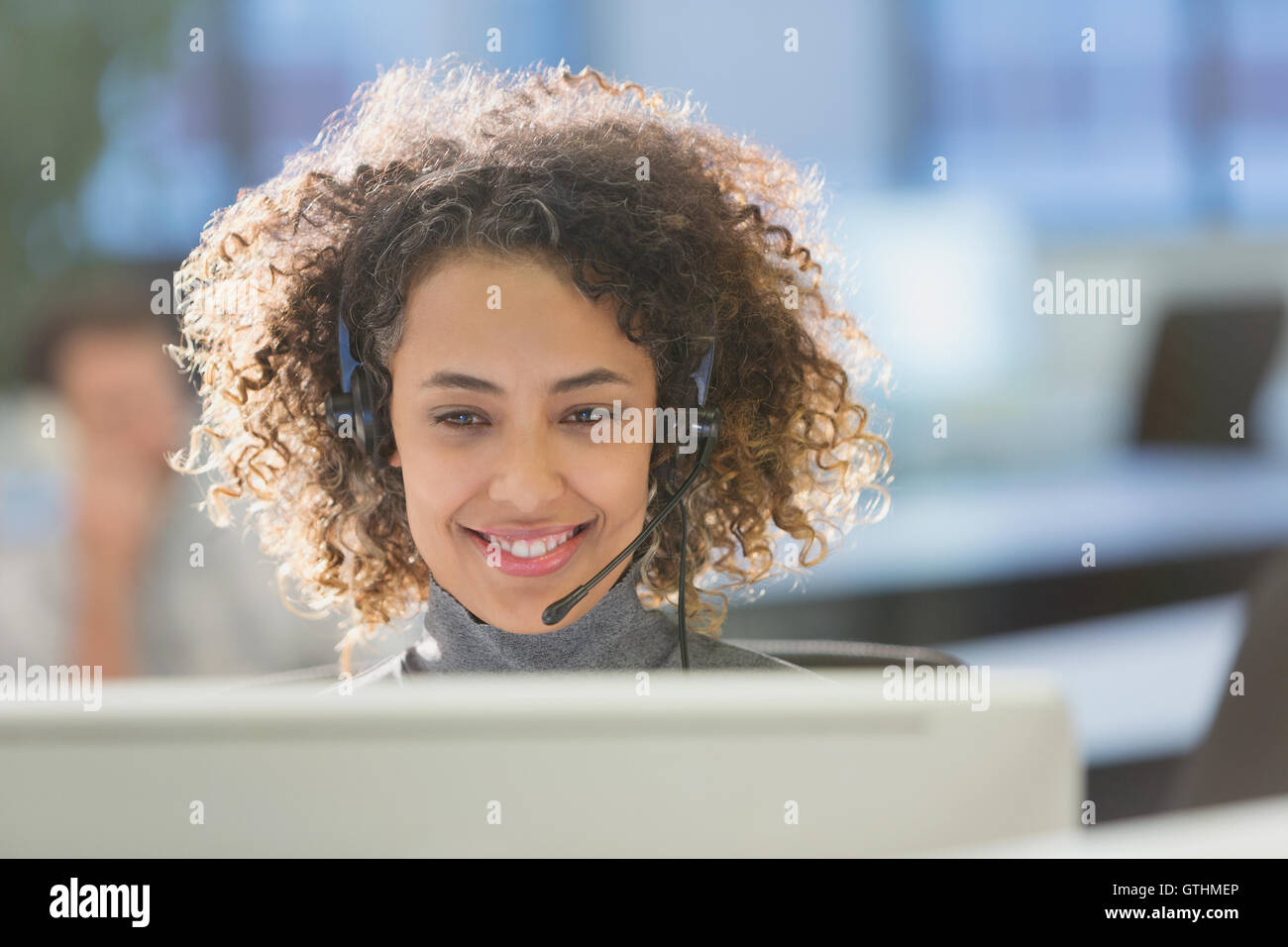 Geschäftsfrau mit Kopfhörer arbeiten am Computer im Büro Stockfoto