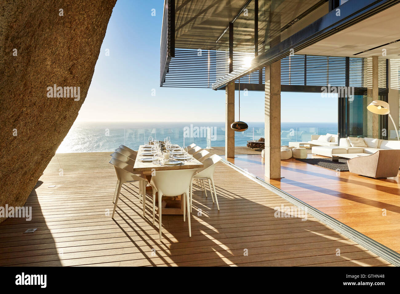 Moderne Luxus Esstisch auf der sonnigen Terrasse mit Blick aufs Meer Stockfoto