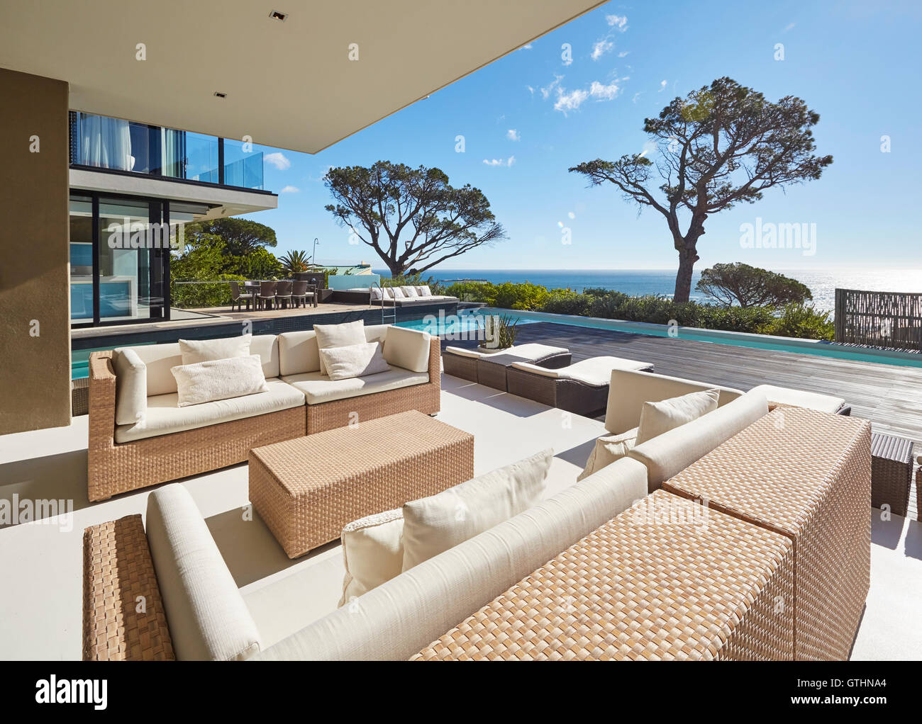 Moderne Luxus nach Hause Schaufenster Patio mit sonnigen Meerblick Stockfoto