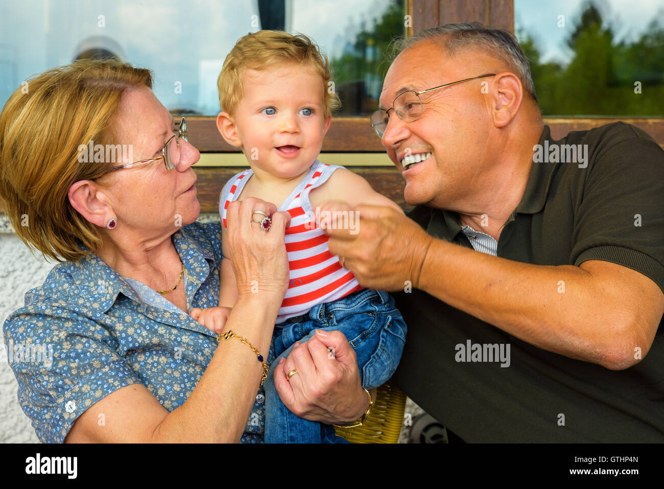 Familie Moment, Großeltern, die mit viel Spaß mit ihrem Enkelkind. Stockfoto