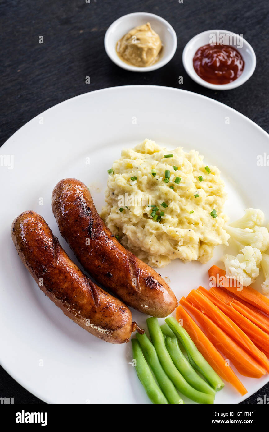 Deutsche Bratwurst mit gestampften Kartoffeln und Gemüse einfache Mahlzeit Stockfoto