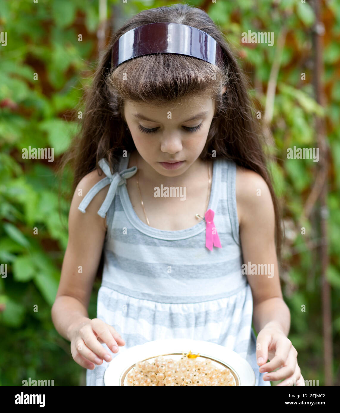 kleines Mädchen hält ein Schild mit einem weißen Johannisbeeren Stockfoto