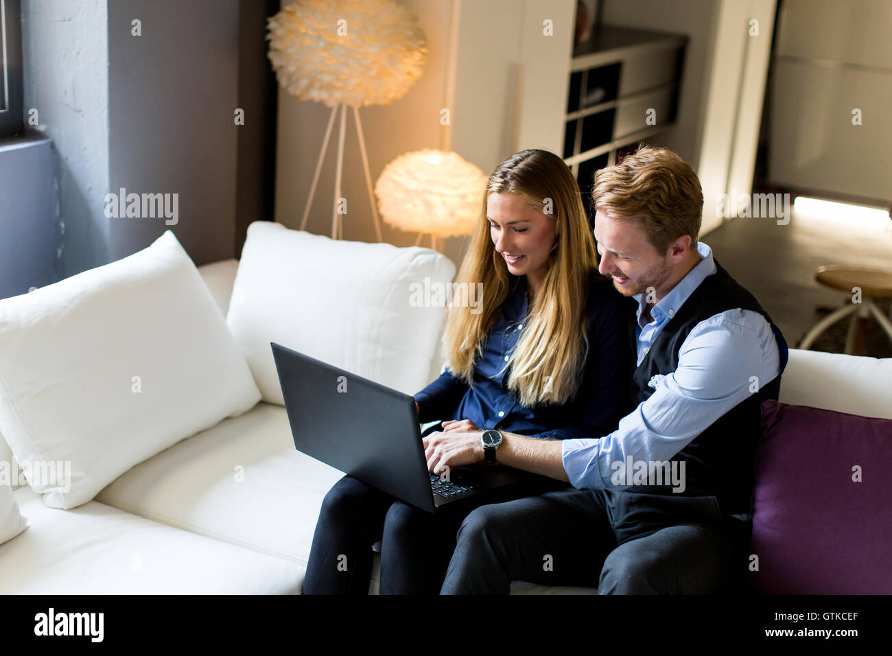 Junges Paar sitzt auf dem Sofa und Surfen im internet Stockfoto