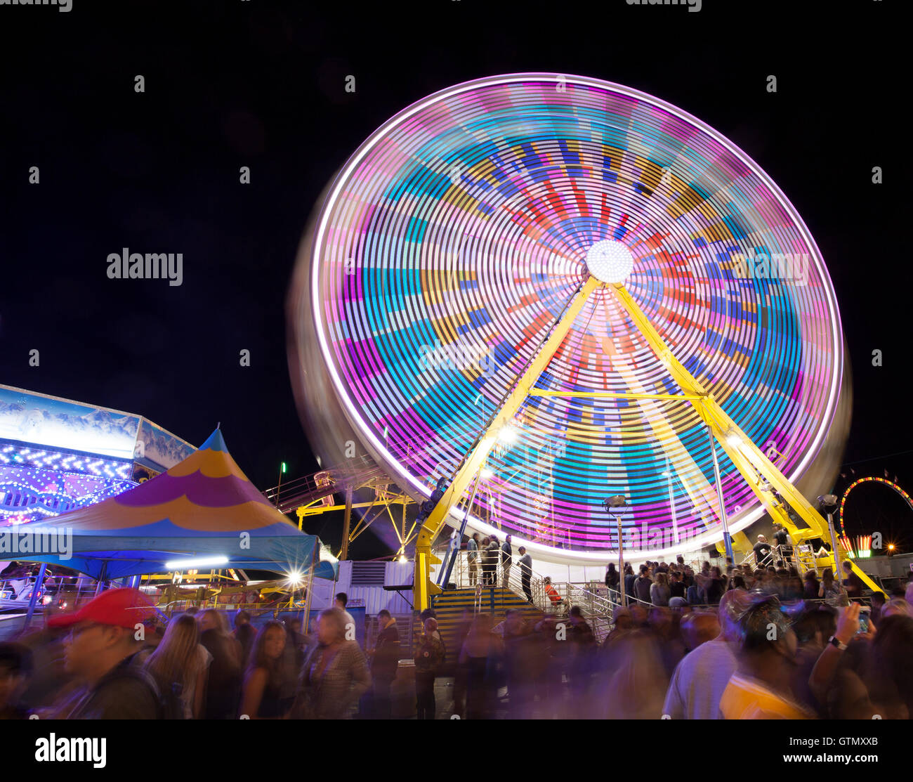 Ferris wheel in der Nacht mit Lichtern und Unschärfe Bewegungseffekt Stockfoto