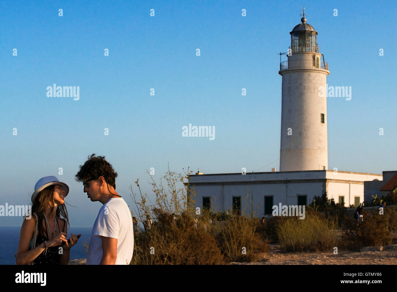 Sonnenuntergang. Junges Paar Touristen in den Leuchtturm Faro De La Mola Formentera, Pityusen, Balearen, Spanien, Europa Stockfoto