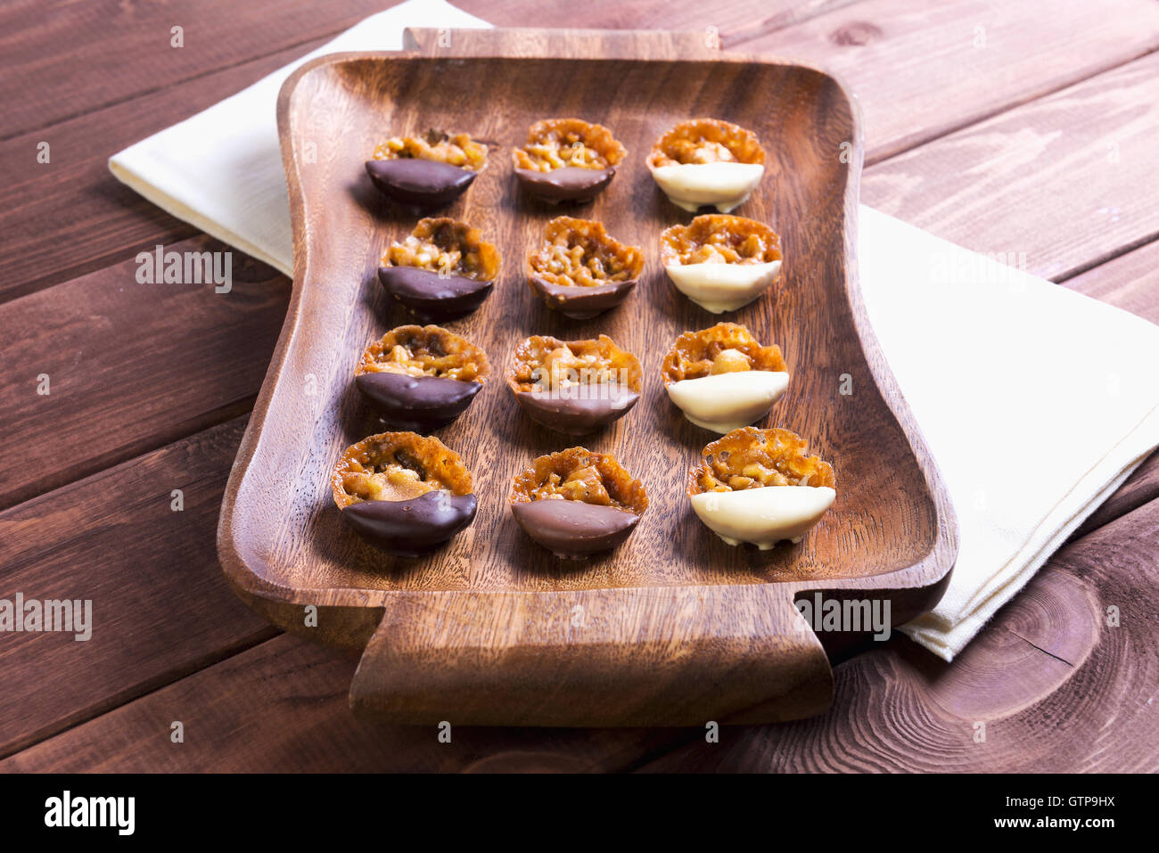 Auf einem Holztisch im Vintage-Stil Tablett mit hausgemachten Bonbons mit Nüssen und Schokolade auf Beige Serviette Baumwolltuch Stockfoto