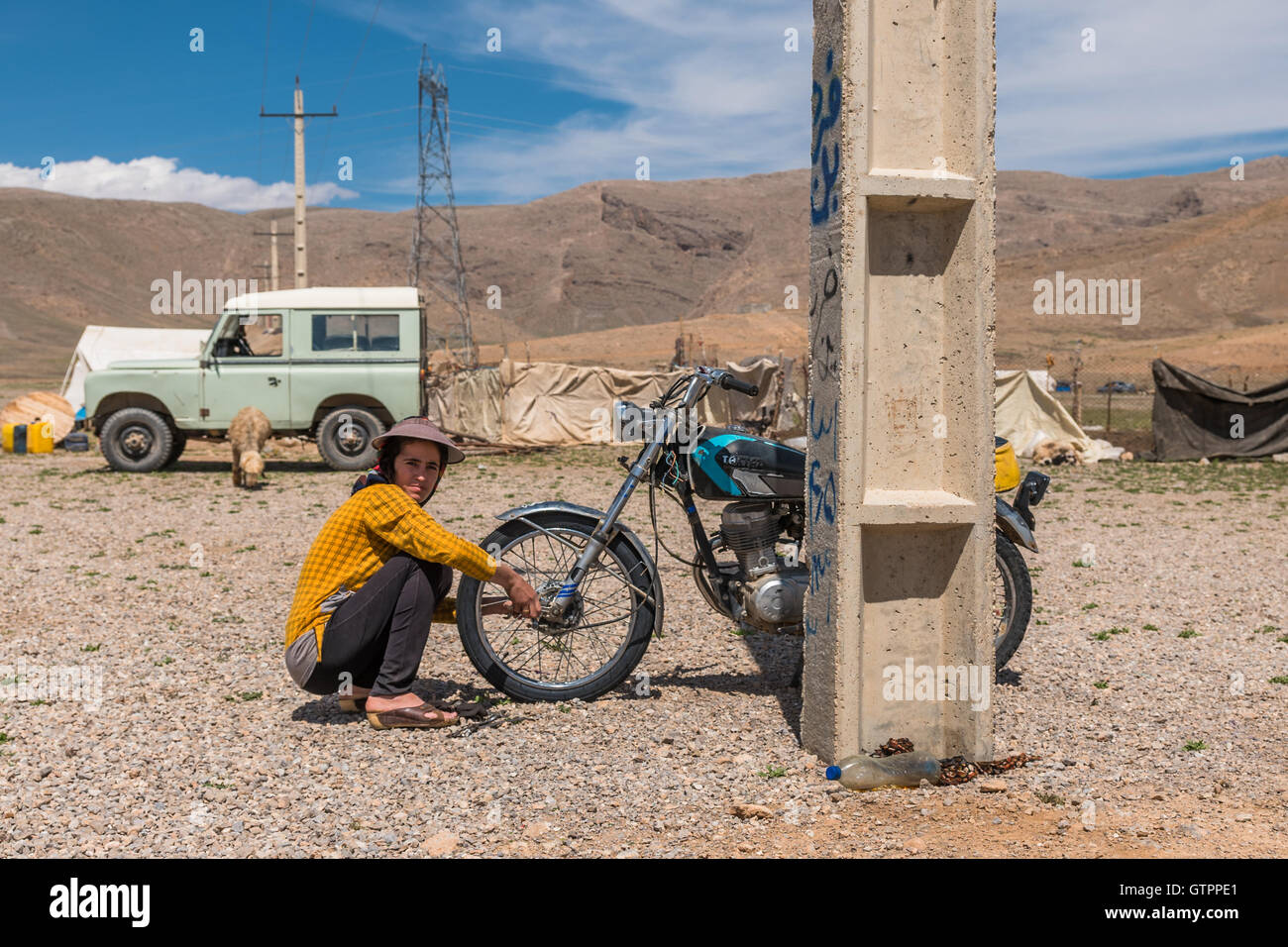 Eine nomadische Qashqai Familie lebt in einem Zelt in der Provinz Fars, Iran. Tochter Donya arbeiten an ihrem Motorrad in der Nähe der Familienzelte. Stockfoto