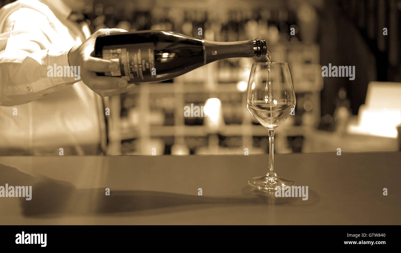 Barkeeper gießt fizzy Wein im Glas an der Bar Theke. Stockfoto