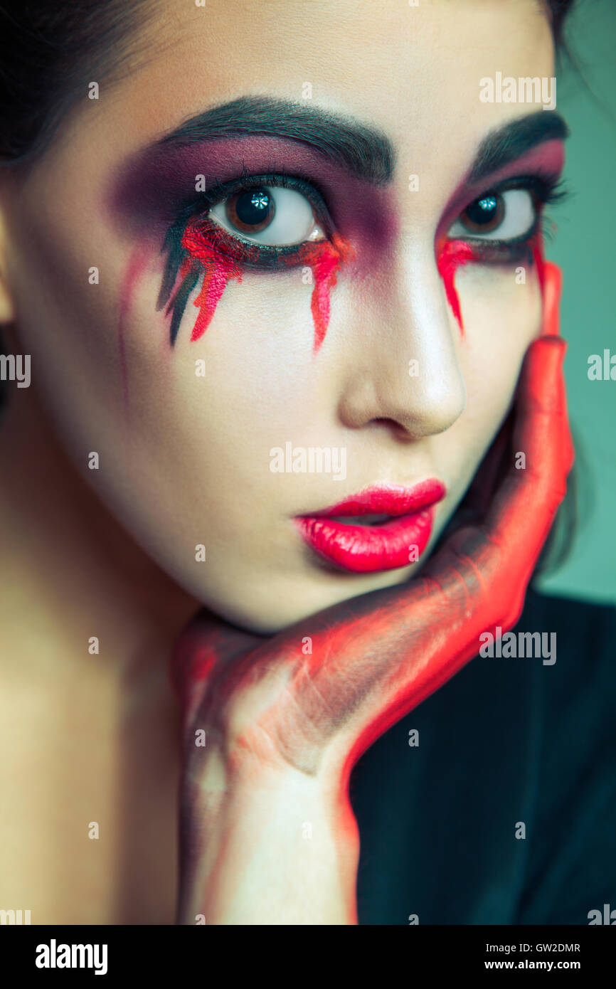 Porträt von Freak-Monster mit Chaos schmutzig gefärbt Make-up im Gesicht.  weinende Frau mit roten blutige Tränen und Hand Stockfotografie - Alamy