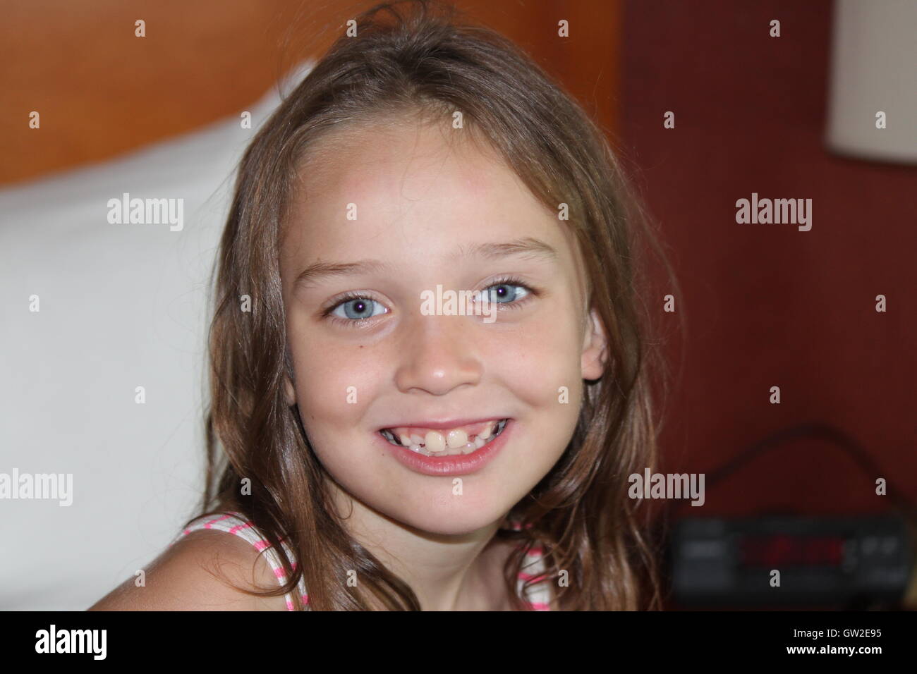 Mädchen mit einem bildhübschen Lächeln in die Kamera schaut. Stockfoto