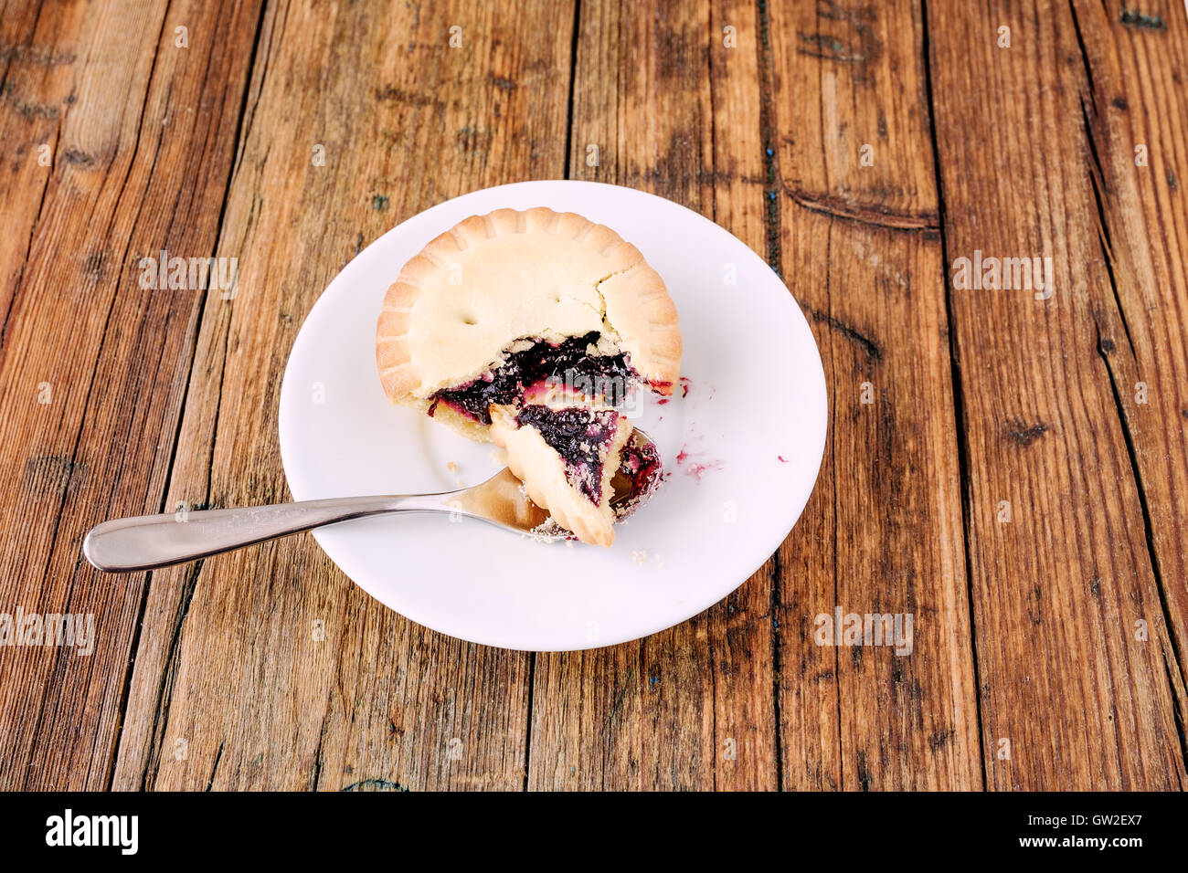 Mince Pies mit Berry Stau in auf einem weißen Teller auf dem Tisch mit einem Löffel Stockfoto