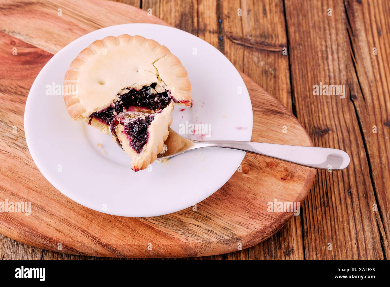 Mince Pies mit Berry Stau in auf einem weißen Teller auf dem Tisch mit einem Löffel Stockfoto