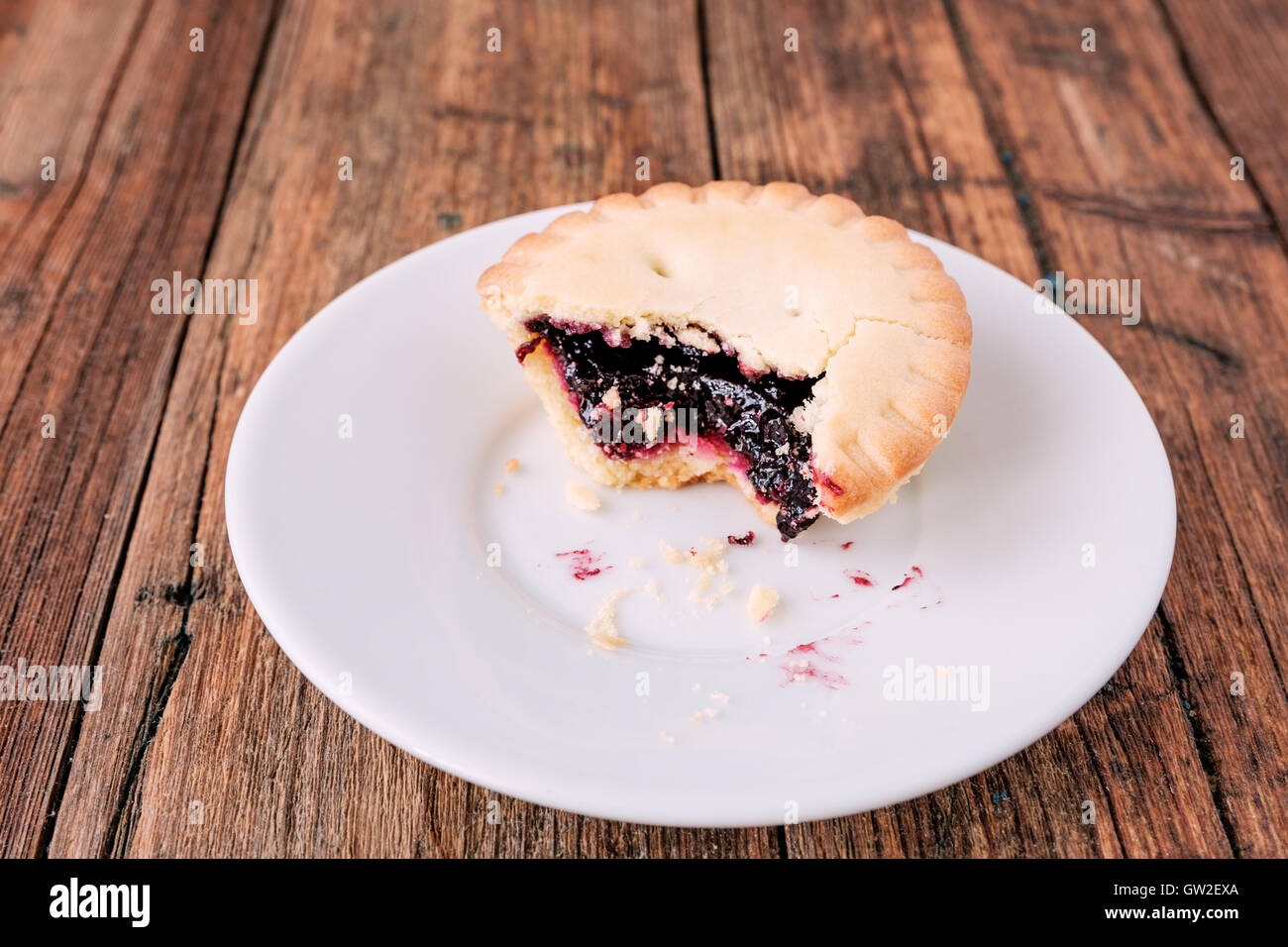 Mince Pies mit Berry Stau in auf einem weißen Teller auf dem Holztisch Stockfoto