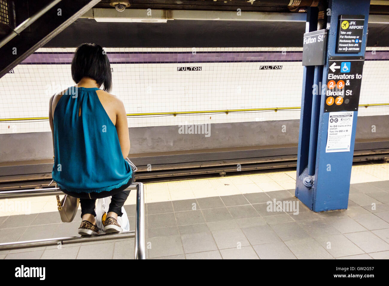 New York City, NY NYC Lower Manhattan, Finanzviertel, Fulton Center, U-Bahn, Station, MTA, Plattform, Erwachsene, weibliche Frauen, auf Geländer sitzend, r Stockfoto
