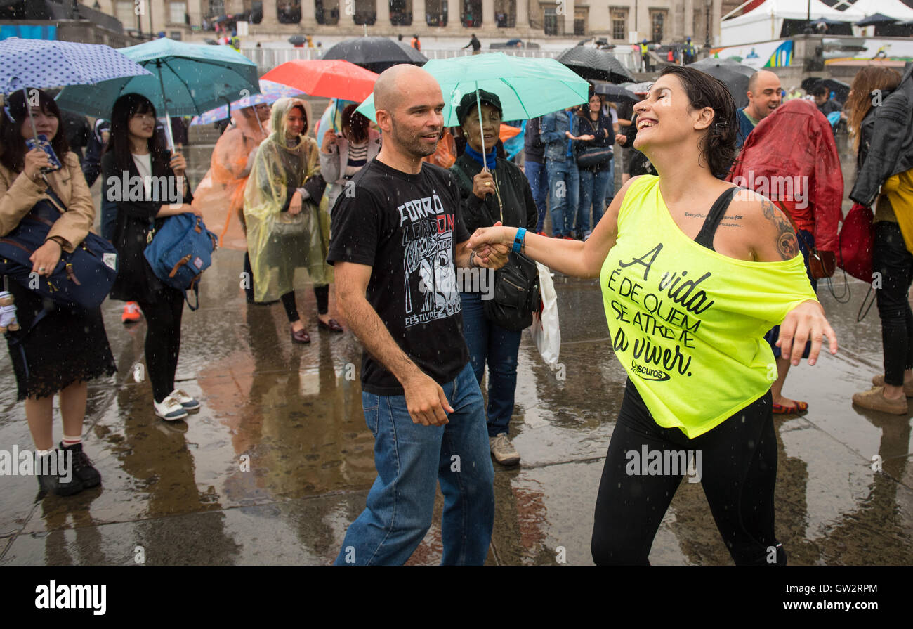 Tanzen im Regen am Trafalgar Square in London, während Brasilien Tag 2016, eine Feier des Rio 2016 Olympischen und Paralympischen Spiele und brasilianischen Kultur. Stockfoto