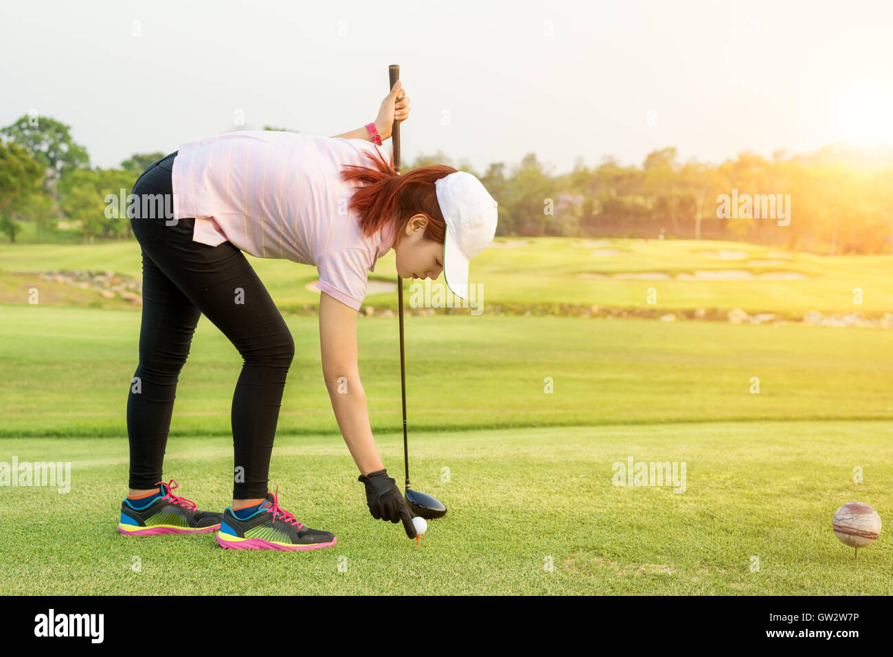 Asiatische Frau gesetzt Golfball auf Tee bereits um Golf zu spielen. Golf-Sport-Konzept. Stockfoto