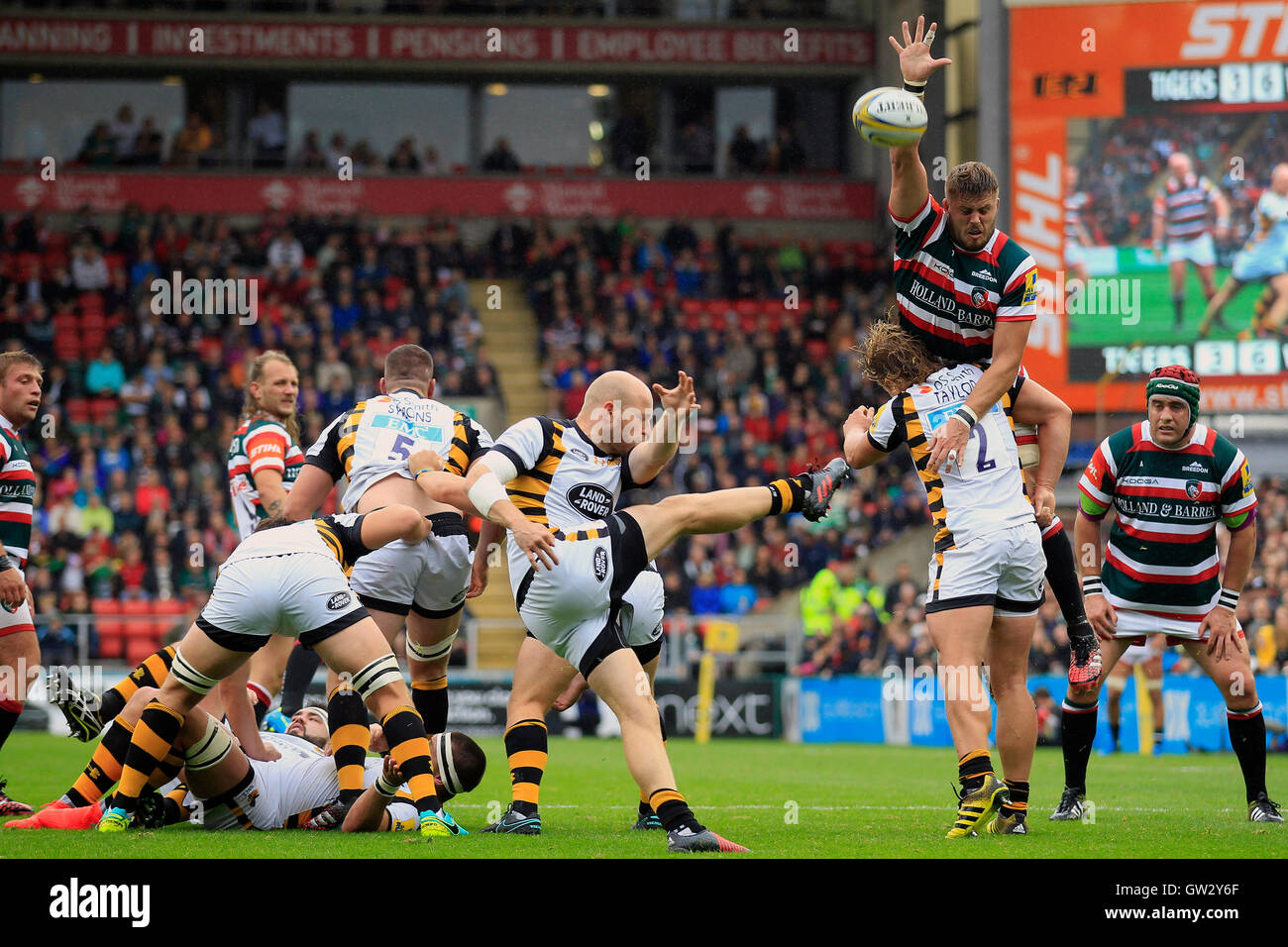 Wespen Joe Simpson (Mitte) Kick wehrt während des Spiels der Aviva Premiership Welford Road Stadium, Leicester Leicester Tigers Ed Slater. Stockfoto