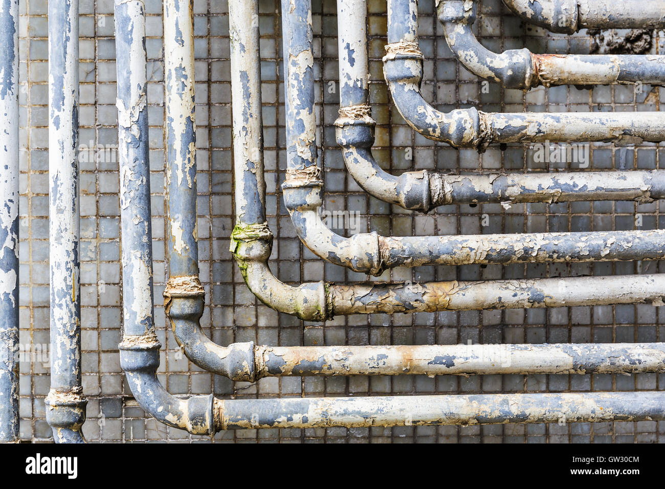 Reihe von parallelen alte Rohre an Wand Stockfoto