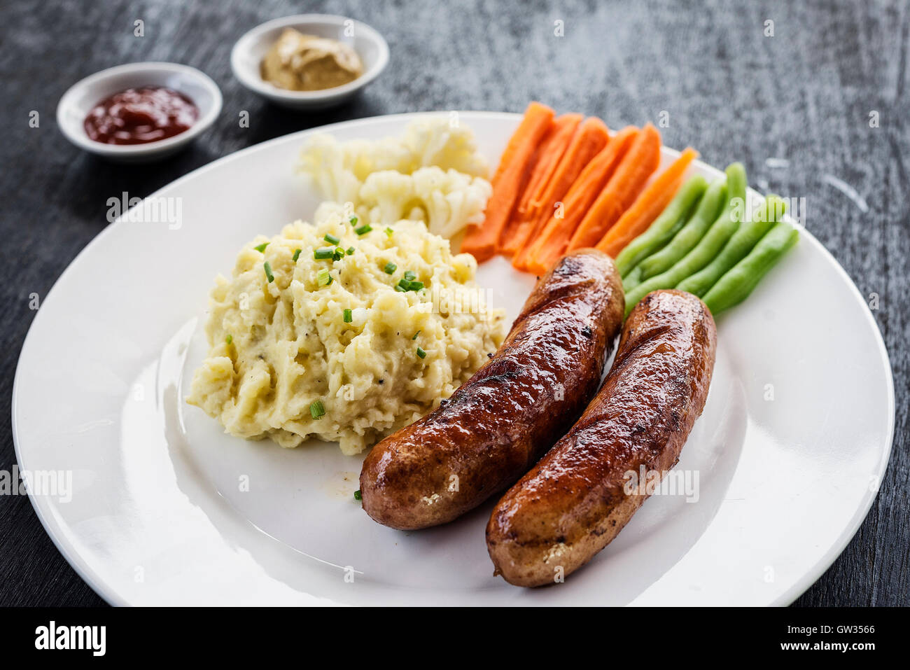 Deutsche Bratwurst mit gestampften Kartoffeln und Gemüse einfache Mahlzeit Stockfoto