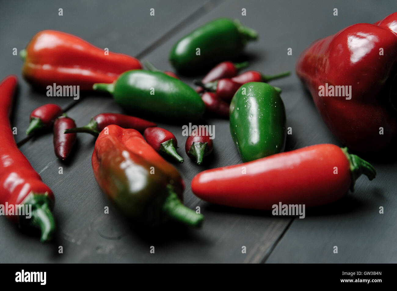 Rote und grüne Chilischoten auf dunklem Holz Hintergrund Stockfoto