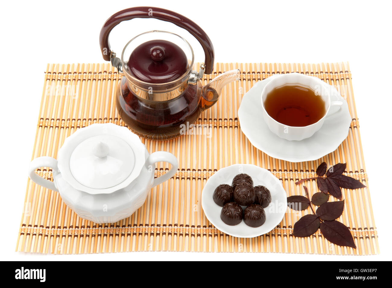Tasse Tee und Süßigkeiten in eine Untertasse auf der Matte Stockfoto