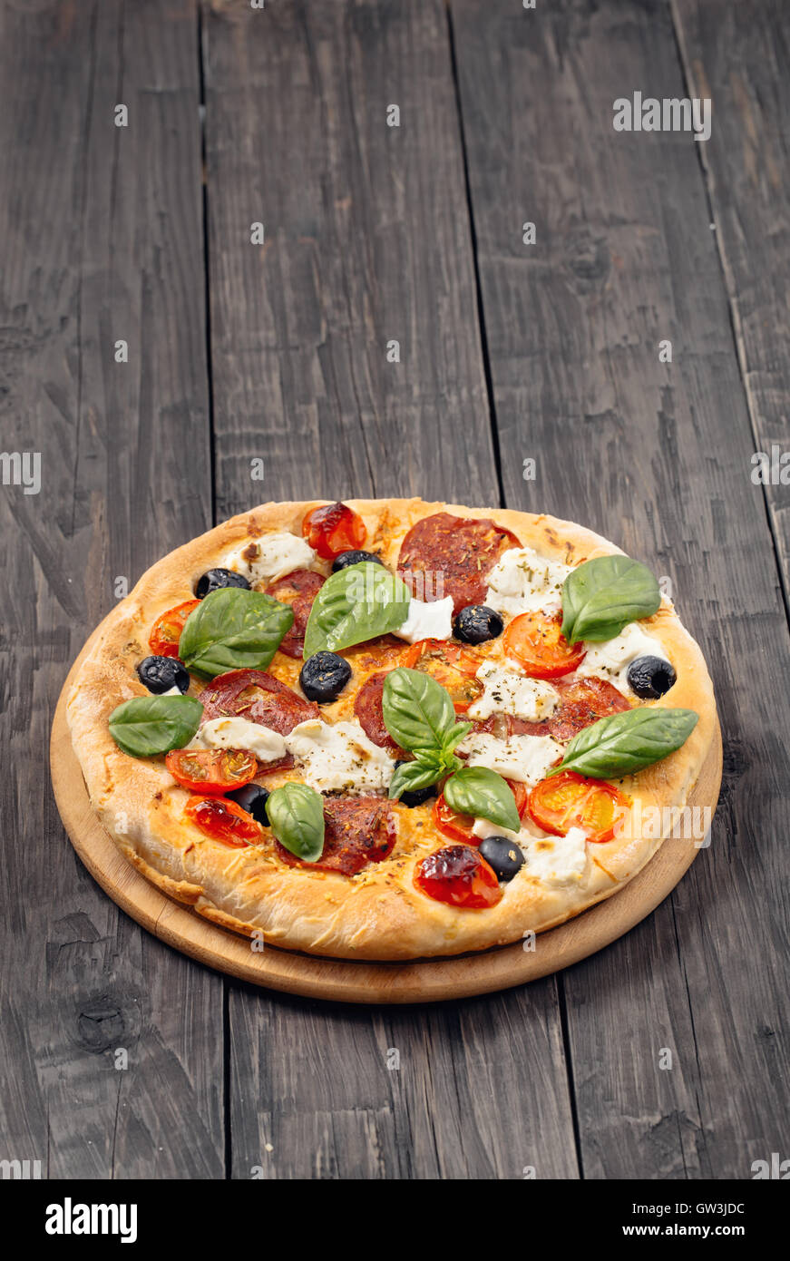 Pizza mit Salami und Mozzarella rustikal Stockfoto