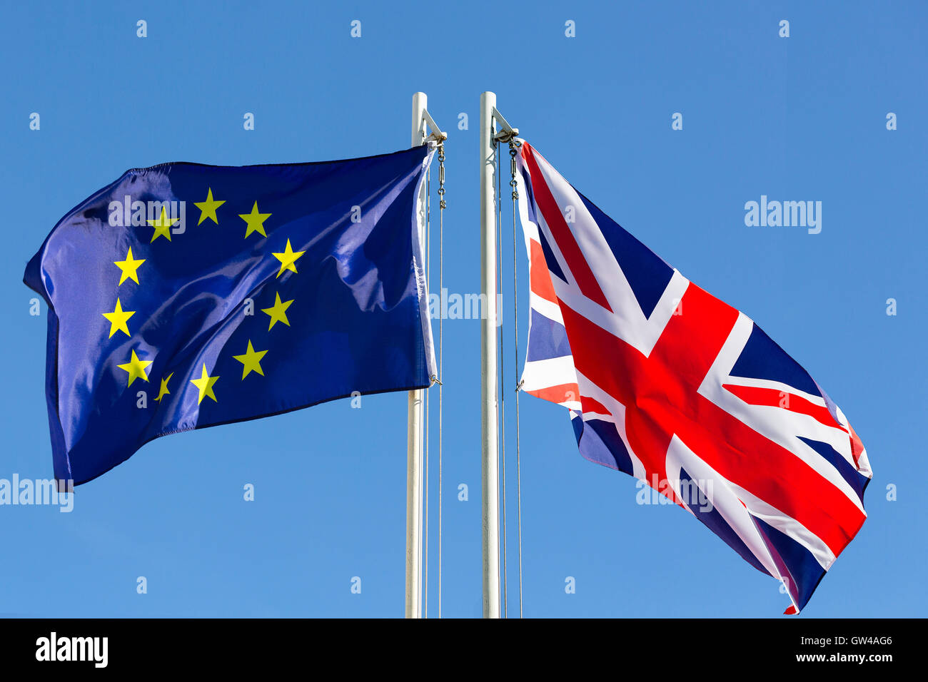 EU-Flagge und die Flagge des Königreichs am Fahnenmast vor blauem Himmel Stockfoto