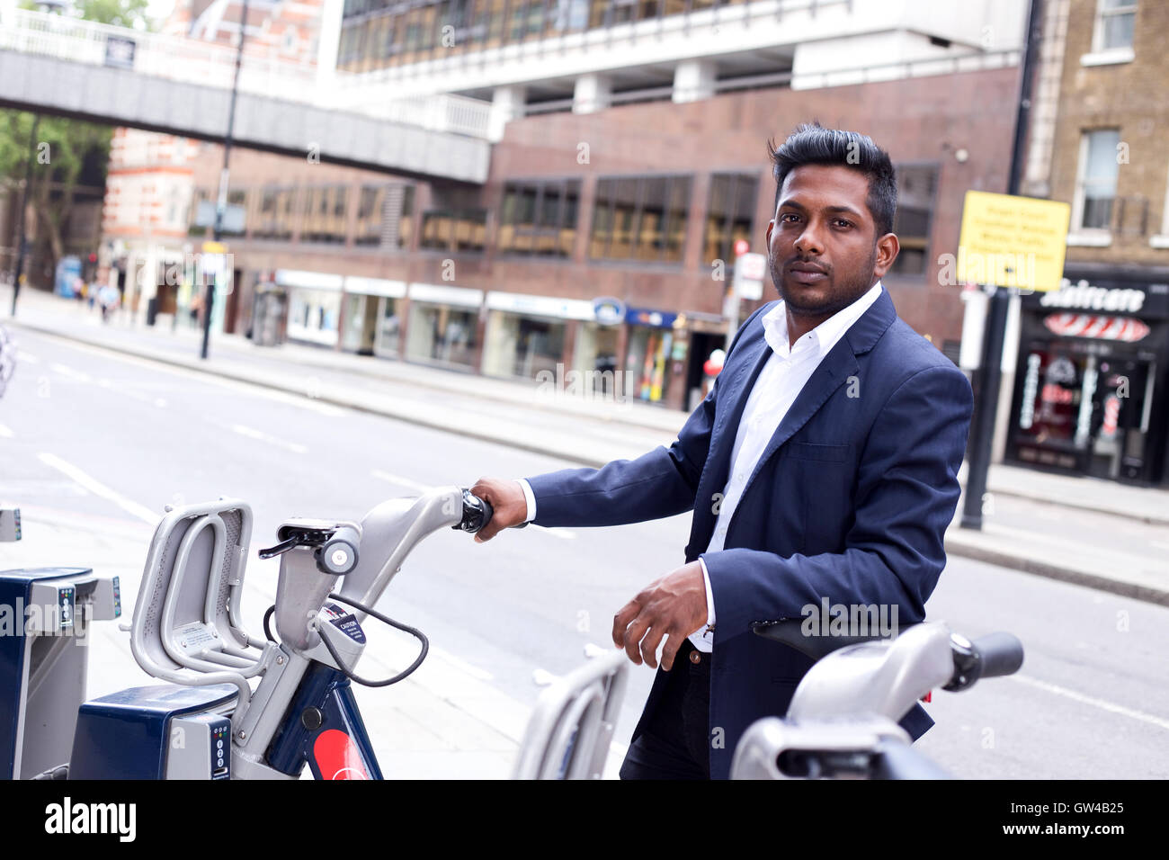 Indische Geschäftsmann herausnehmen ein Fahrrad mieten in der Stadt Stockfoto
