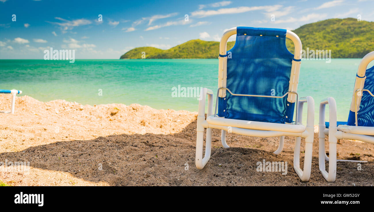 Liegestühle am Strand von Daydream Island, einer abgelegenen Insel in den Whitsundays vor der Küste von Queensland Stockfoto