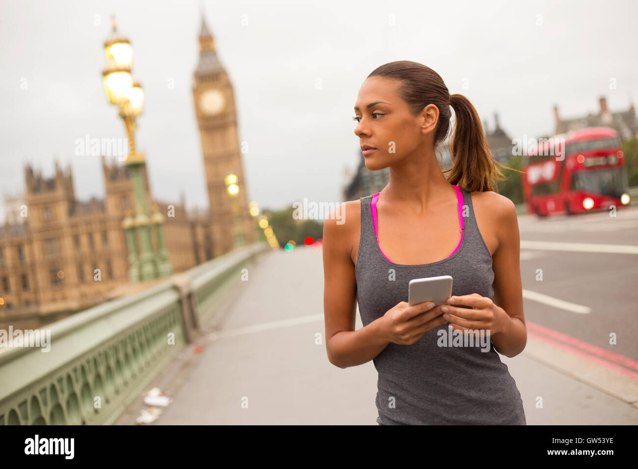 Fitness-Frau in London mit ihrem Telefon Stockfoto
