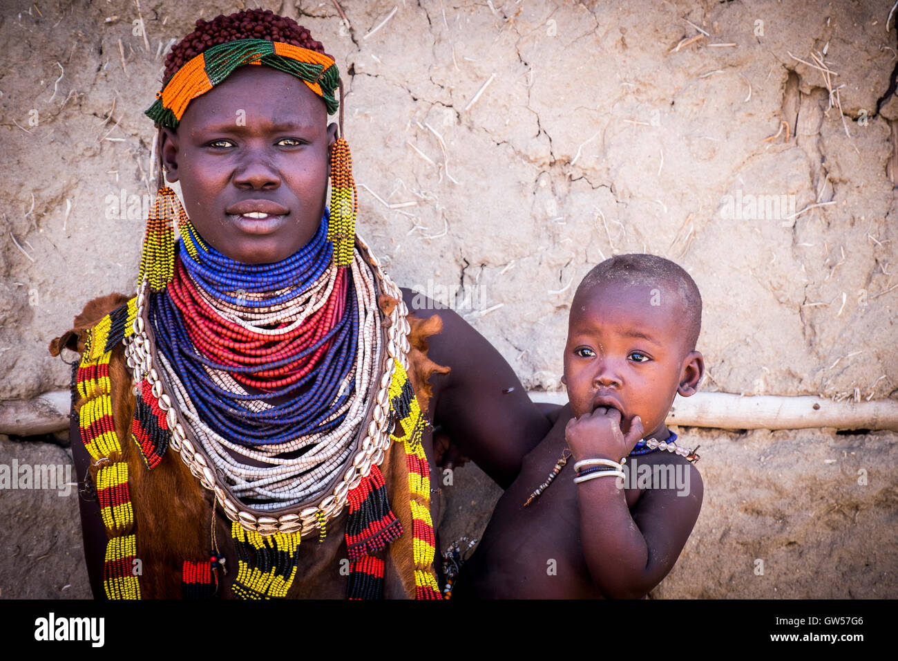 Eine Frau und ihr Kind des Stammes Karo im Omo Tal von Äthiopien.  Sie trägt große Perlen Verzierungen. Stockfoto