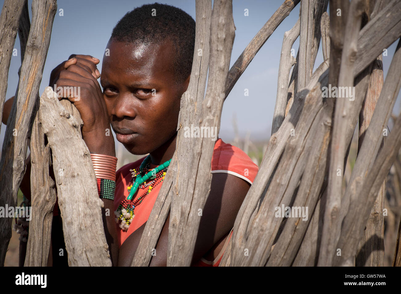 Porträt eines jungen Mannes aus dem Hamer Stamm im Omo Tal des südlichen Äthiopien Blick durch ein Gehege rund um sein Haus Stockfoto