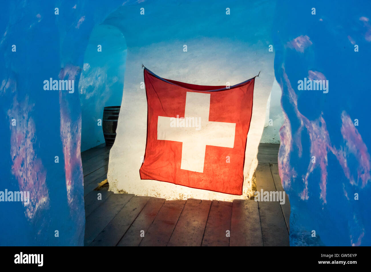 Schweizer Flagge in einem Eis Höhle im Rhonegletscher, beleuchtet von hinten  durch das Eis Stockfotografie - Alamy